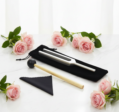 384Hz weighted tuning fork with wooden mallet and black velvet pouch on white marble with soft pink roses — Heavenly Crystals Online