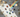 Prism casting rainbow light across chakra crystals including garnet, carnelian, citrine, malachite, lapis lazuli and amethyst on white marble