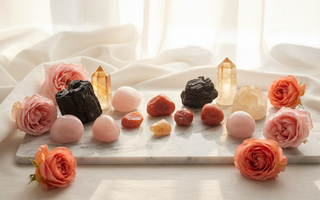 Citrine, sunstone, rose quartz, carnelian and black tourmaline crystals on white marble with soft pink roses — uplifting crystals for depression support by Heavenly Crystals Online
