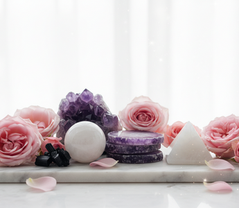 Amethyst, lepidolite, moonstone, black tourmaline and howlite crystals on white marble with soft pink roses — calming crystals for sleep disturbance and nightmares by Heavenly Crystals Online