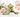 Jade panda holding bamboo, turtle carving and green bead bracelet arranged on white marble, surrounded by soft pink roses.