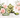 Jade panda holding bamboo, turtle carving and green bead bracelet arranged on white marble, surrounded by soft pink roses.