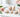 Peach Moonstone crystal shapes in soft peach and cream, arranged with pink roses on white marble.