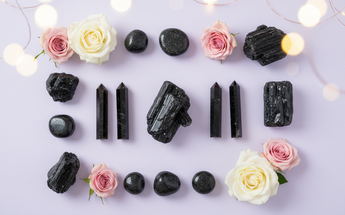 Black tourmaline crystals and protection stones arranged with roses and fairy lights