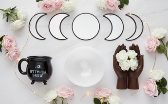 Home decor mirrors, mugs, teapots and bowls arranged with roses and fairy lights