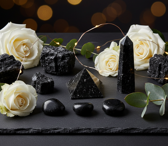 Black Tourmaline crystals in various shapes with white roses and fairy lights – Heavenly Crystals Online