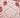 Copper dowsing rods laid on a pink surface surrounded by blush roses and rose petals, used for divination, spirit communication, and energy mapping