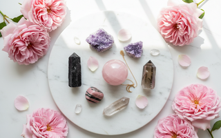 Black tourmaline, lepidolite, rose quartz, rhodonite and smoky quartz crystals on white marble with soft pink roses — healing crystals for Complex PTSD support by Heavenly Crystals Online.