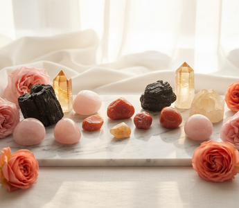 Citrine, sunstone, rose quartz, carnelian and black tourmaline crystals on white marble with soft pink roses — uplifting crystals for depression support by Heavenly Crystals Online