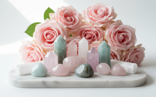 Rose quartz, aquamarine, labradorite, kunzite and selenite crystals on white marble with soft pink roses — healing crystals for emotional neglect history by Heavenly Crystals Online.