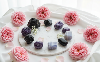 Black tourmaline, lepidolite, smoky quartz, obsidian and blue lace agate crystals on white marble with soft pink roses — grounding crystals for trauma-driven dysregulation by Heavenly Crystals Online