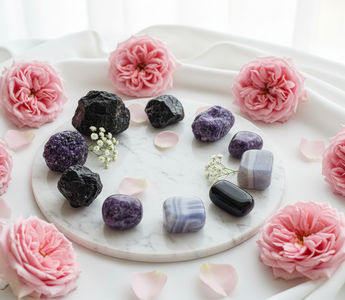 Black tourmaline, lepidolite, smoky quartz, obsidian and blue lace agate crystals on white marble with soft pink roses — grounding crystals for trauma-driven dysregulation by Heavenly Crystals Online