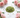 Polished peridot crystal chips with soft pink roses on white marble