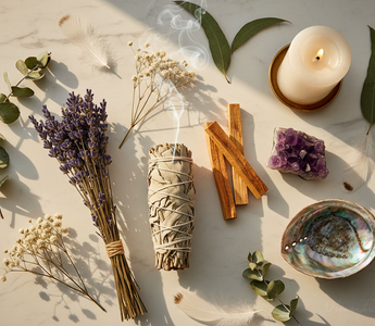 White sage bundle, Palo Santo sticks, amethyst, dried lavender and abalone shell flatlay for smudging and energy cleansing on white marble