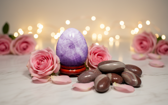 Amethyst crystal egg and shiva lingam stone with pink roses and fairy lights - sacred healing tools