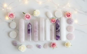Crystal massage wands, Vogel crystals and healing tools arranged with roses and fairy lights