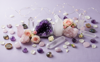 Healing crystals and spiritual stones in various forms arranged with roses and fairy lights
